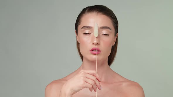 Beautiful Young Woman with Clean Fresh Skin Standing Over Light Grey Background alt