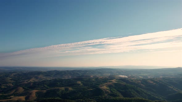 Aerial time lapse of morning landscape and clouds, at sunrise, over hills