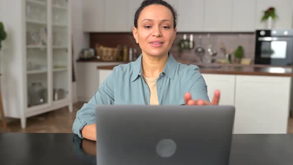 Positive Smart Female Freelancer Sitting at the Table with Laptop