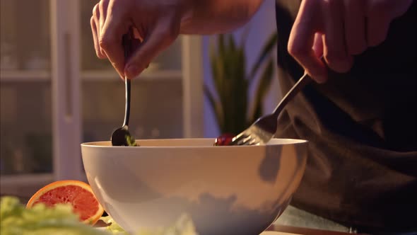 Male Hands Mix Salad with Balsamic Vinegar