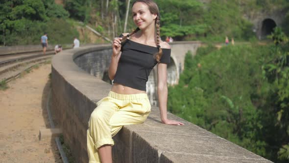 Girl Sits on Famous Old Bridge Located Among Wildlife Nature alt