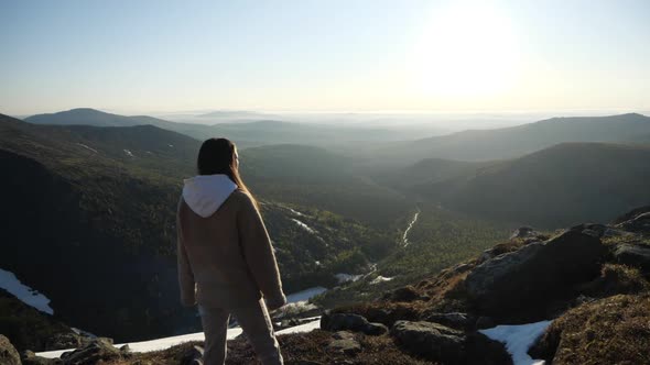 A Woman Watching Sunrise Over at the Top of the Mountain