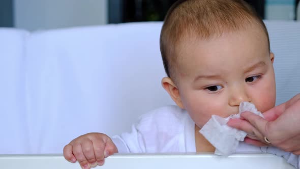 Cute portrait of a baby in a crib close-up. A child in white clothes on white underwear. Tenderness alt