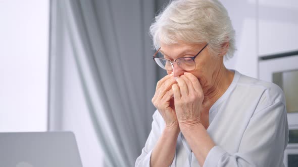 Upset aged businesswoman with grey hairstyle wipes nose with paper napkin alt