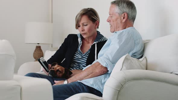 Retired Senior Couple at home with digital tablet