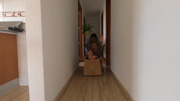 Couple of adult having fun together in a new house playing with a small box alt