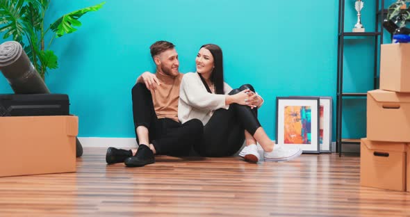 American Family Couple Sitting on Floor in New Apartment Dreaming About Future alt