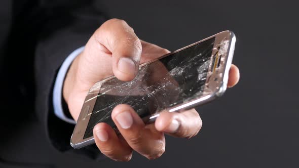 Close Up of Man Hand Holding Broken Smart Phone alt