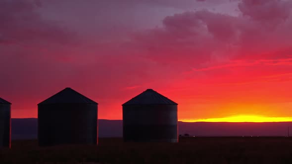 Panning past grain bin during vibrant sunset it Idaho alt
