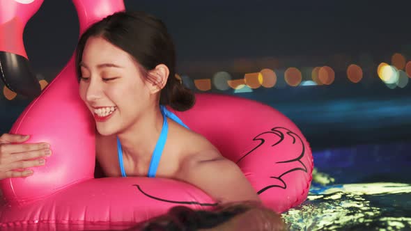 Asian young woman relaxing in swimming pool at luxury hotel spa alt