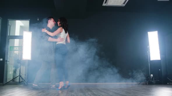 Pretty Couple Dancing in Front of a Black Background in a Dance Studio alt