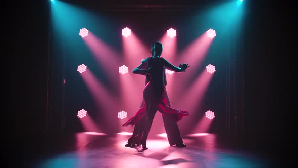 Silhouette of Dancers in a Smoky Ballroom. Passionate Couple Dancing Tango in a Dark Room with alt