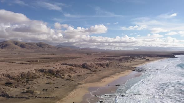 A Body of Water with a Mountain and Clouds in the Background