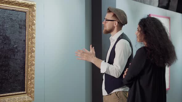 Man Is Admiring Contemporary Artwork in Gallery Talking with Woman alt