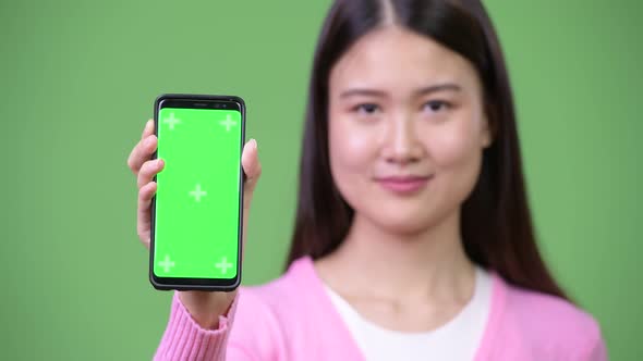 Young Beautiful Asian Woman Showing Phone
