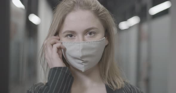 Closeup Portrait of Young Caucasian Woman Taking Off Covid19 Face Mask and Smiling alt