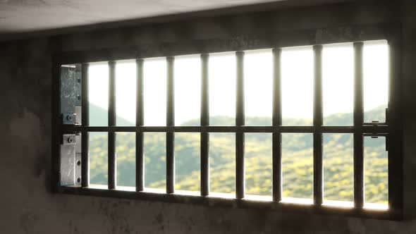 Animation of a grunge prison cell with landscape outside the barred-up window. alt