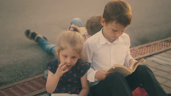 Children in Classic Dressing Prepare for Hard Exam Outdoors alt