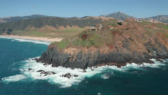 Panoramic Aerial View on Incredible Shore with Lighthouse on High Rocky Island. alt