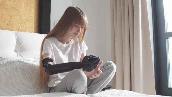 Girl Checking Her Robotic Mechanical Arm Indoors