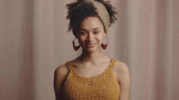Young Fashionable Stylish African American Woman with Ethnic Accessories Smiling to Camera Beige alt