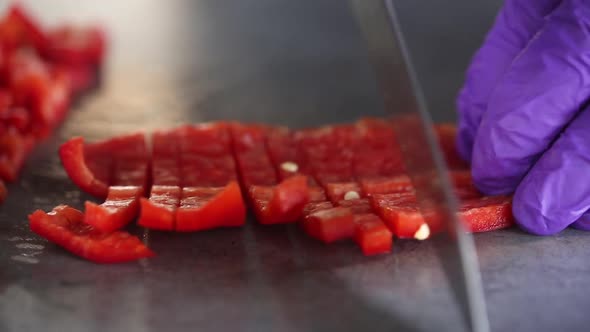 Chef cuts red peppers on a cutting board