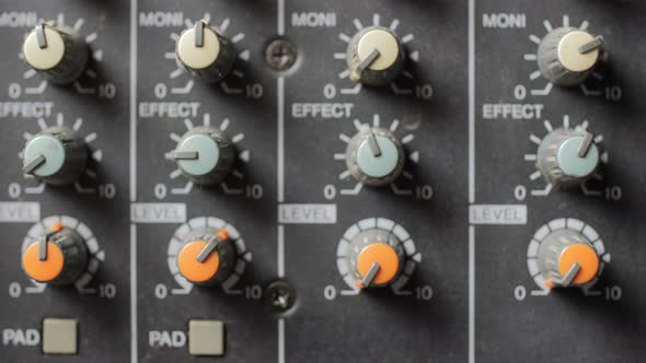 Old dusty audio console closeup. Changing lighting. Focus on knobs. alt