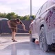 A Man Washes His Car During the Day Washes of the Foam - VideoHive Item for Sale