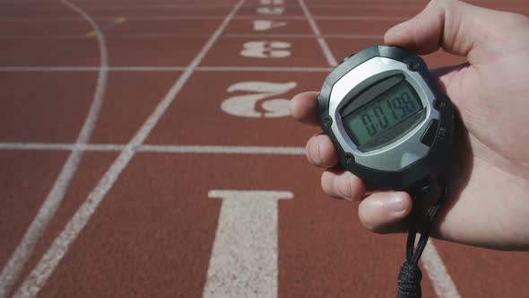 Male Hand Turning on Stopwatch to Record Time During Sport Competition, Deadline alt