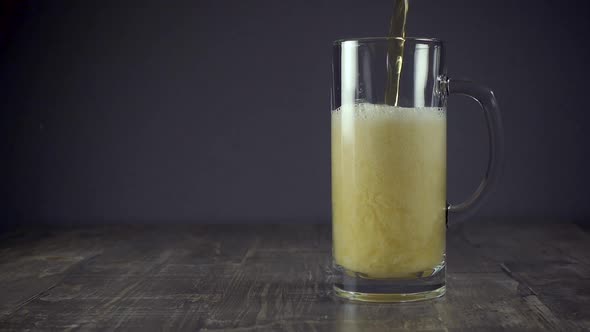 Slow Motion Pour Light Beer in a Mug on a Grey Background