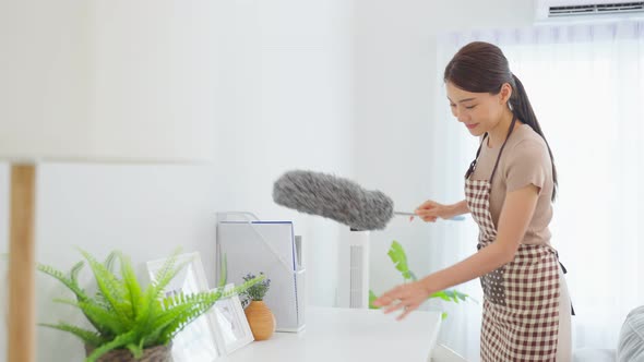 Asian cleaning service woman worker cleaning in living room at home. alt