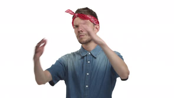 Sassy Handsome Caucasian Guy with Red Bandana Standing in Hiphop Pose Having Rap Battle Nodding at