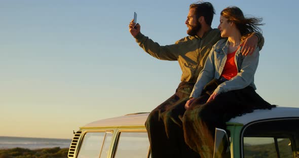 Couple taking selfie during sunset on beach 4k alt