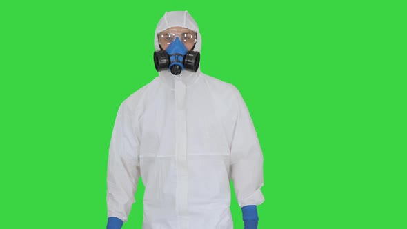 Virologist Man in Protective Costume Checking the Situation on a Green Screen, Chroma Key. alt