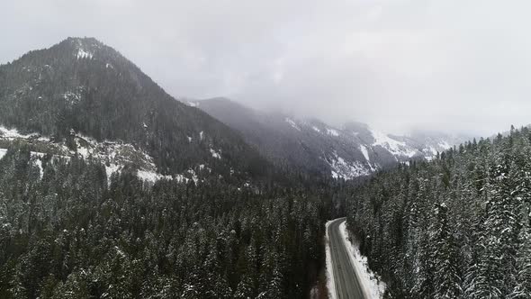 Cars Driving Epic Mountain Highway Road Stormy Fog Snow Winter Conditions Evergreen Tree Forest alt
