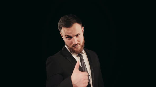 A Man in a Suit is Standing on Stage and Looking at the Camera alt