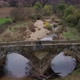 Drone aerial view of a couple on an ancient historic stone bridge in Idanha a velha, Portugal - VideoHive Item for Sale