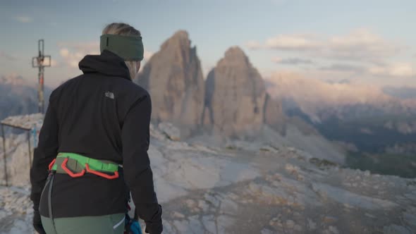 A person with climbing gear walking in front of the famous three peaks - tre cime - Dolomites. alt