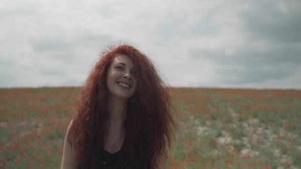 Beautiful Woman with Freckles on Background of Poppy Field alt