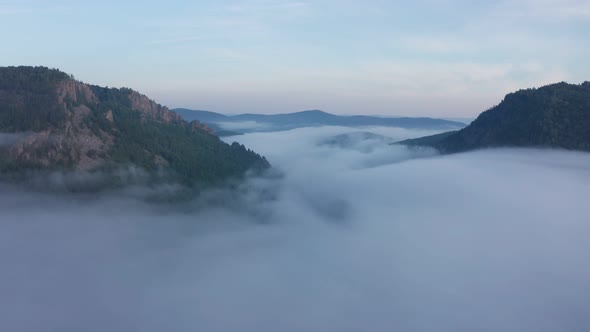 Aerial View Over Clouds in a Valley Between Ural Mountains on a Sunrise