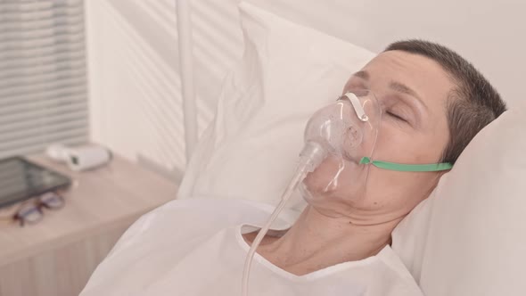 Woman in Oxygen Mask in Hospital Bed alt
