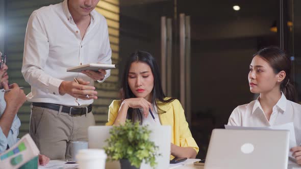 Asian young business man and woman people group have discussion meeting in office late at night. alt