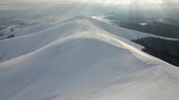 Amazing Aerial Flight Over Misty Mountain Range Meadows and Snow Covered Peaks in Winter Time alt