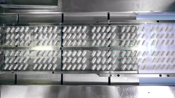 Top View of a Conveyor Transporting Medication Capsules alt