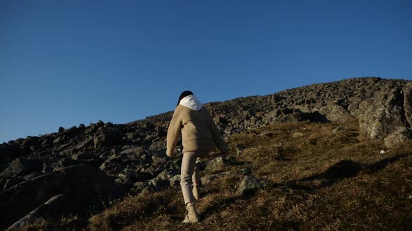 A Lonely Traveller Girl Walks Uphill Walking Through the Mountainous Terrain