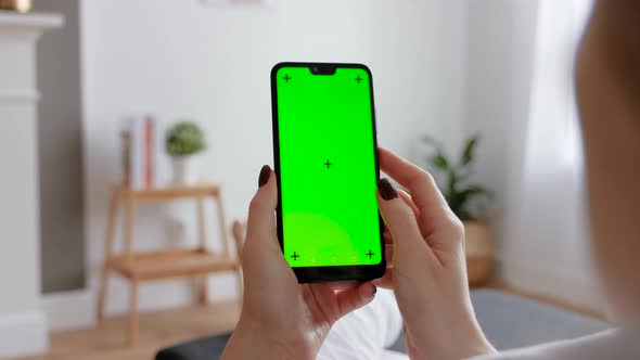 Young Female Using Smart Phone Sitting On Sofa At Home.