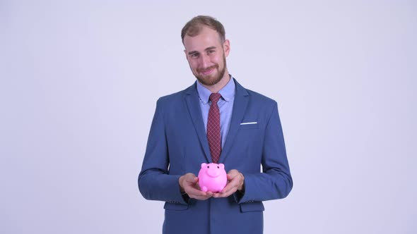Happy Bearded Businessman Holding Piggy Bank