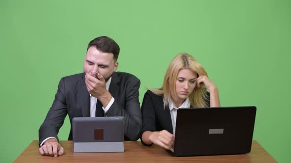 Young Business Couple Looking Bored While Working Together