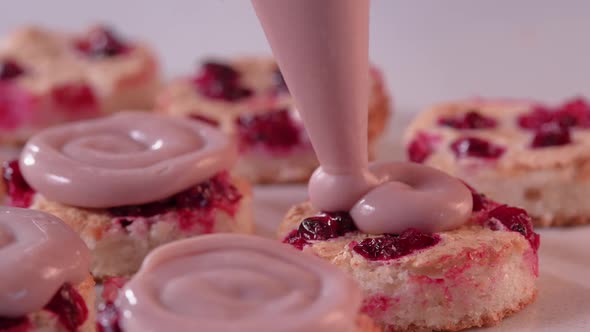 Pastry Chef Squeezes Pink Cream From a Pastry Bag Onto the Mini Cake alt