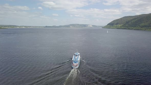 Aerial View of Moving Motor Ship on Wide River in Sunny Day, Following Boat
